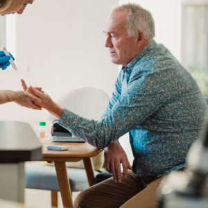 Diabetiker bekommt Blut abgenommen Ein Mann bekommt Blut abgenommen, um den Blutzucker zu messen. Das Bild von Canva soll auf die Diabetiker Selbsthilfegruppe hinweisen.