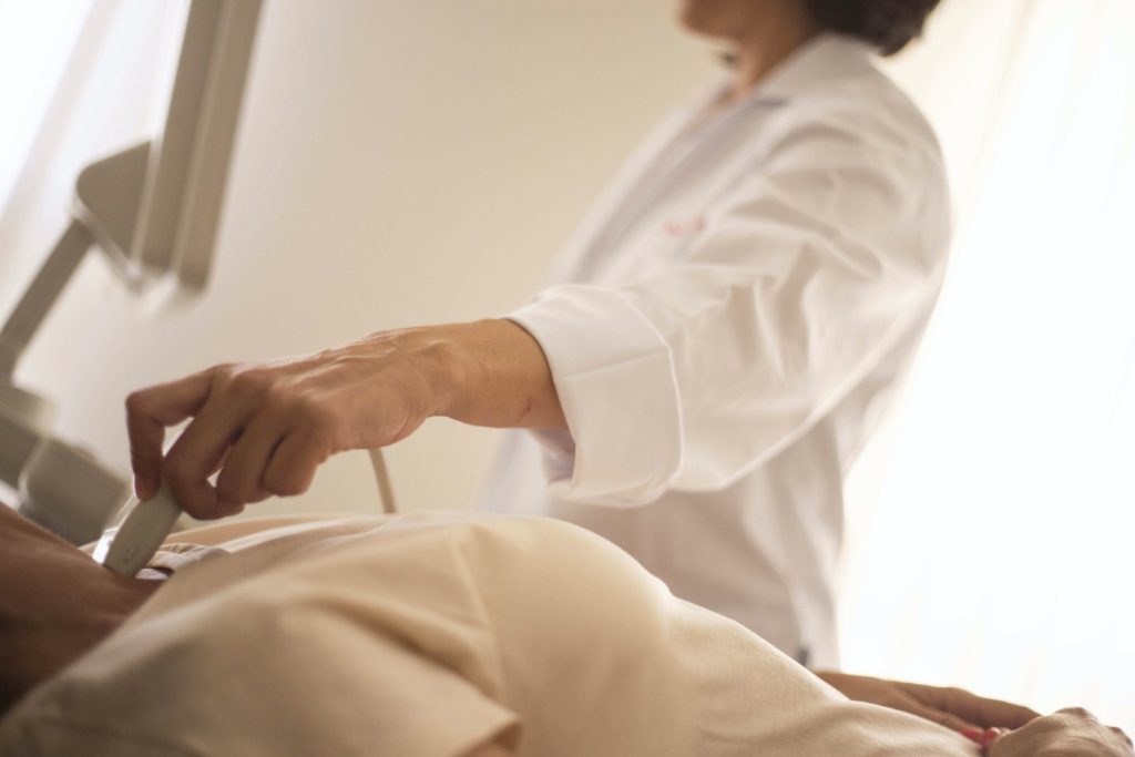 Hashimoto-Thyreoiditis Schildrüsenerkrankung Eine Ärztin untersucht per Ultraschall die Schilddrüse einer Frau.