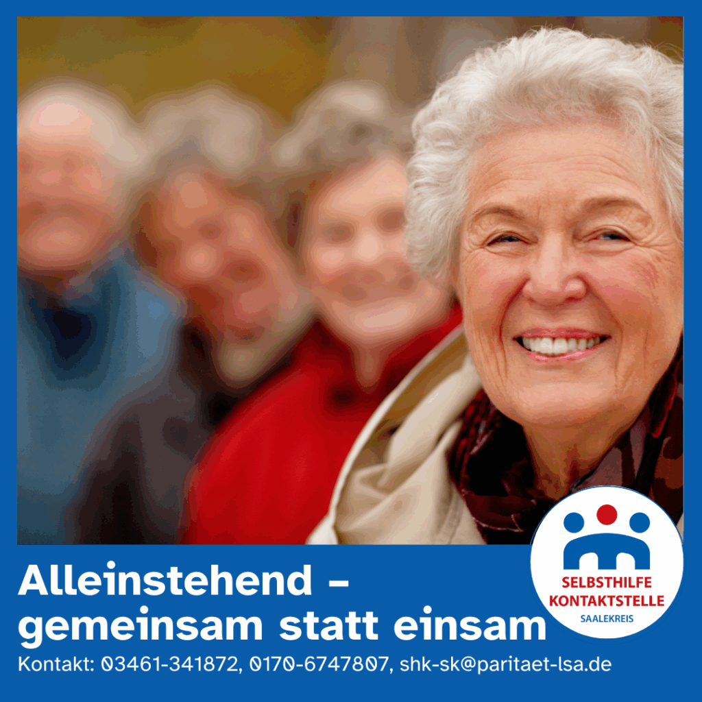 Eine ältere Dame steht vor nur schemenhaft zu erkenenden weiteren älteren Personen lacht in die Kamera.